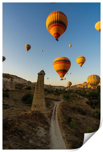 Vertical image of bunch of colorful hot air balloon flying early morning in Cappadocia, Turkey against typical rock formation due to volcanic activity in love valley located in Goreme national park Print by Arpan Bhatia