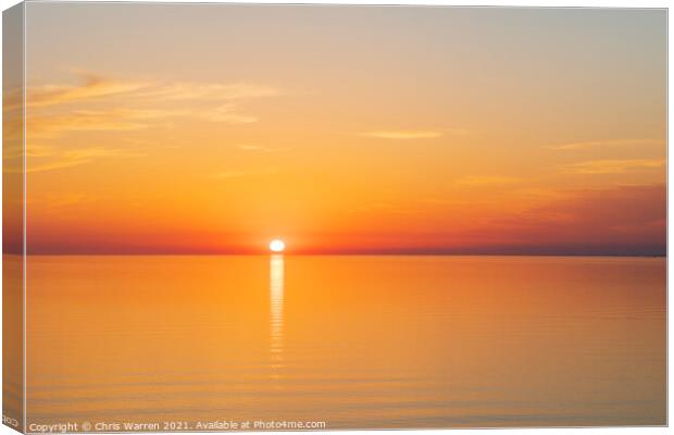 Sun setting over a calm sea Canvas Print by Chris Warren