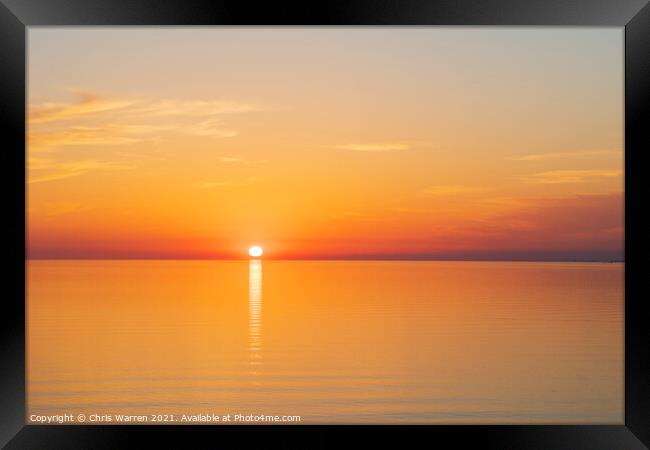 Sun setting over a calm sea Framed Print by Chris Warren