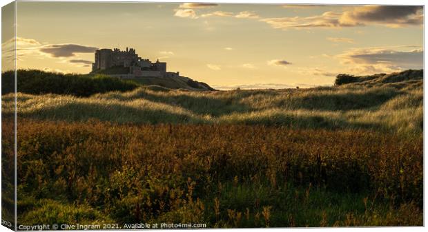 Majestic Bamburgh Castle at Golden Hour Canvas Print by Clive Ingram