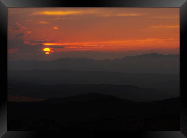 Silhouettes of the mountains under a sunset with the reddish sky Framed Print by Vicen Photo