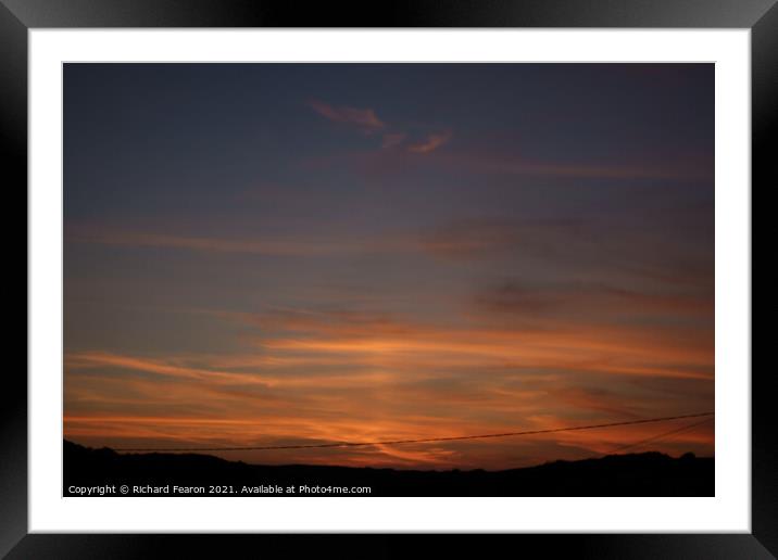 Warm orange sun reflecting off the clouds Framed Mounted Print by Richard Fearon