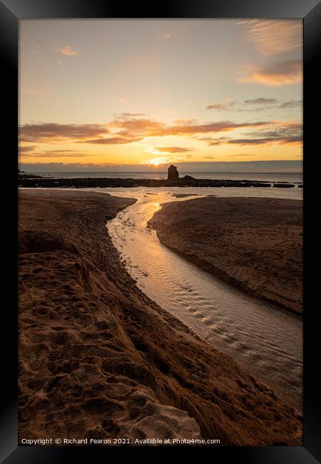 Sun setting behind the rock at Thurlestone. Framed Print by Richard Fearon