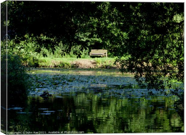 Bench and lily pond Canvas Print by John Rae
