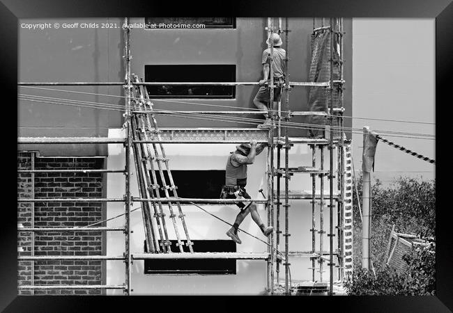 Construction workers dismantling scaffolding on new construction Framed Print by Geoff Childs