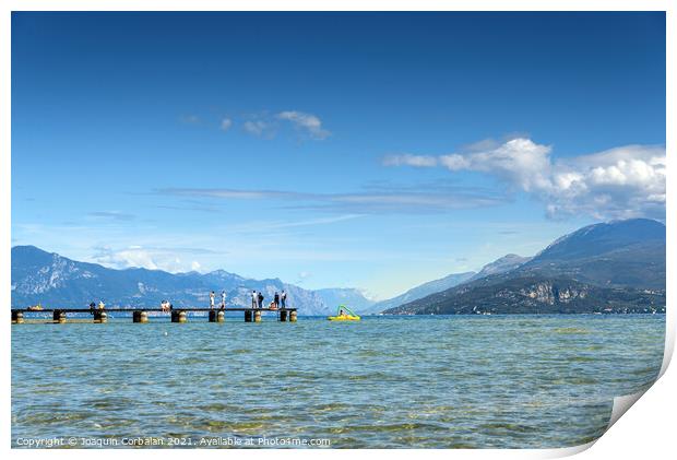Calm water lake in Garda, Italy with a wooden walkway on a sunny Print by Joaquin Corbalan