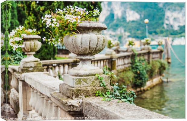 Elegant flower pots decorate the classic stone railing on a roma Canvas Print by Joaquin Corbalan