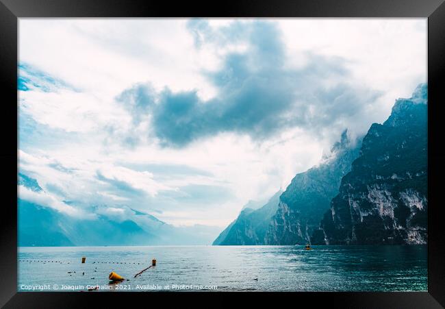 High mountains fall into a glacial lake, seen from Riva del Gard Framed Print by Joaquin Corbalan