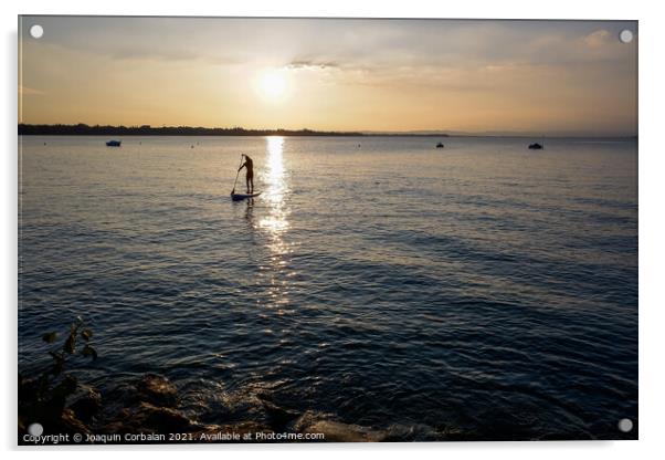 A young man on a paddle surf board approaches the shore of the l Acrylic by Joaquin Corbalan
