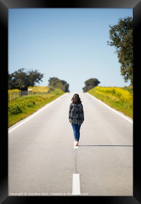 Woman walking on the middle of a road in beautiful yellow flowers landscape in Alentejo, Portugal Framed Print by Luis Pina