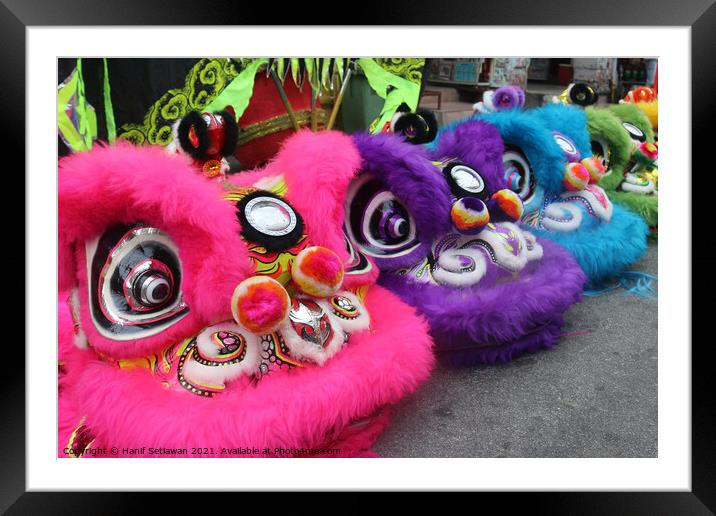 Chinese Dragon masks in three colors on a festival Framed Mounted Print by Hanif Setiawan