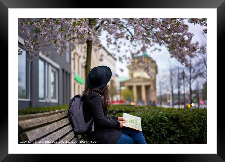 Woman looking at the Brandenburger Tor sited on a bank in Berlin, Germany Framed Mounted Print by Luis Pina