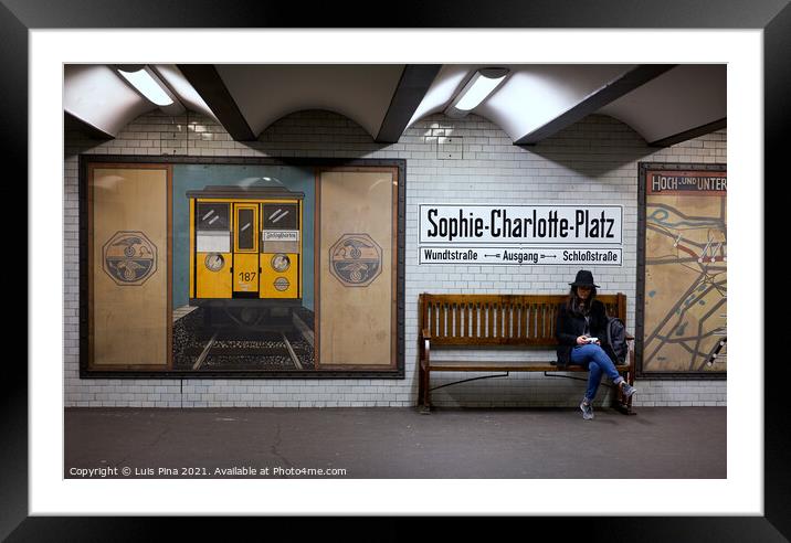 Woman sitting on a bench at Sophie Charlotte Platz subway station in Berlin Framed Mounted Print by Luis Pina