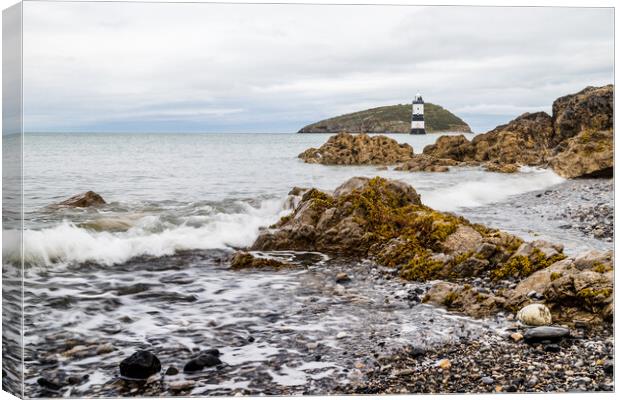 Rocks lead up to Penmon Lighthouse Canvas Print by Jason Wells