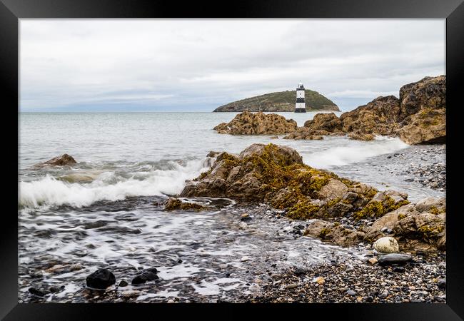 Rocks lead up to Penmon Lighthouse Framed Print by Jason Wells