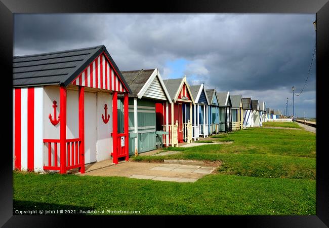 Stormy Skies over beach huts. Framed Print by john hill