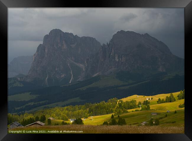 Sassolungo mountains on the Italian Alps Dolomites on the shadow with the sunlight appearing on the landscape Framed Print by Luis Pina