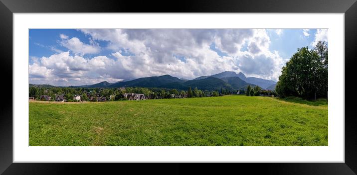 Panoramic view of green grass meadow countryside field with A shaped houses against sleeping knight tatra mountain aka as giewont and dramatic clouds located in Zakopane, South Poland, Europe Framed Mounted Print by Arpan Bhatia