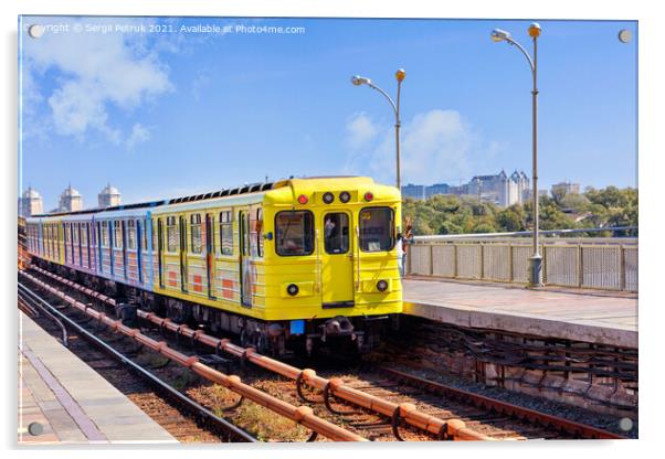A bright yellow metro train departs from the platform and rushes along the metro bridge in Kyiv to the left side of the city. Acrylic by Sergii Petruk