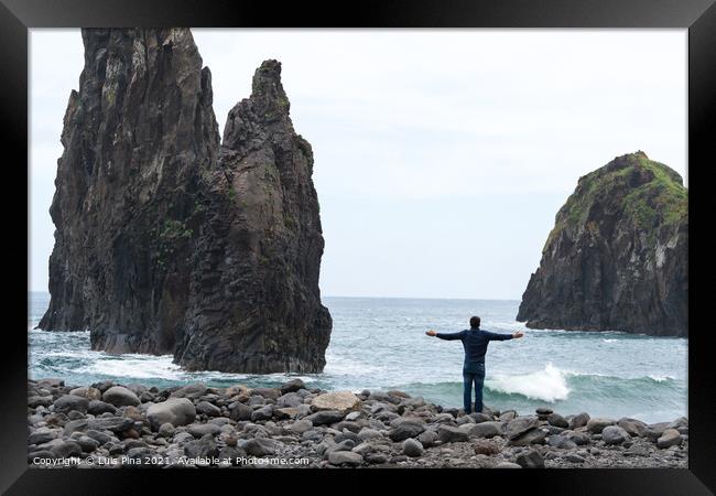 Man with arms wide open looking at Ribeira da Janela islet in Madeira Framed Print by Luis Pina