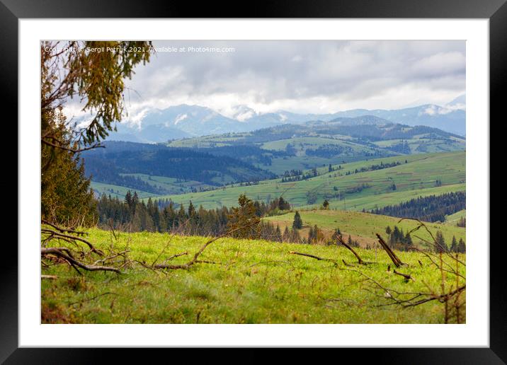 Mountain landscape of spring Carpathians in early spring with low clouds and fresh green grass on the hills. Framed Mounted Print by Sergii Petruk
