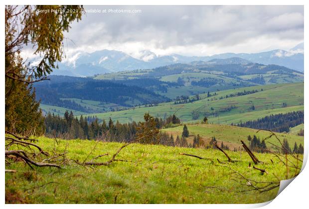 Mountain landscape of spring Carpathians in early spring with low clouds and fresh green grass on the hills. Print by Sergii Petruk