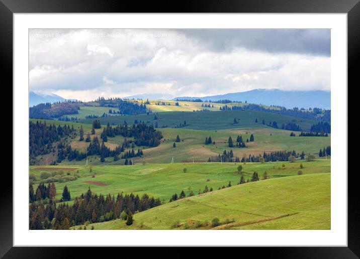 Beautiful mountain landscape of the spring Carpathians with low clouds and glimpses of sunbeams to fresh green grass. Framed Mounted Print by Sergii Petruk