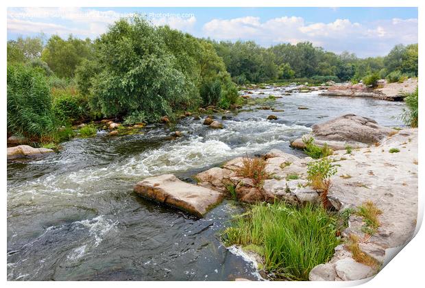 The rapid flow of the river between rocky banks with stone rapids and greenery in a summer landscape. Print by Sergii Petruk