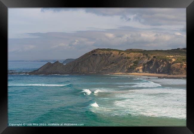 Aljezur beach with waves crashing and sea cliffs on the background Framed Print by Luis Pina