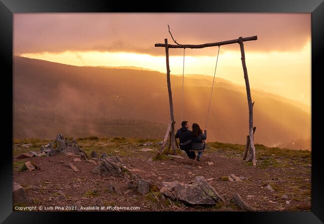 Romantic couple swinging on a Swing baloico in Lousa mountain, Portugal at sunset Framed Print by Luis Pina