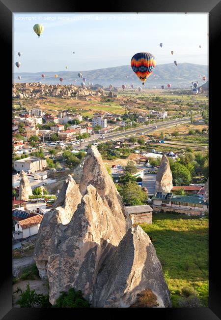 Dozens of balloons fly over the city of Goreme in Turkey and over the valleys of Cappadocia. Framed Print by Sergii Petruk