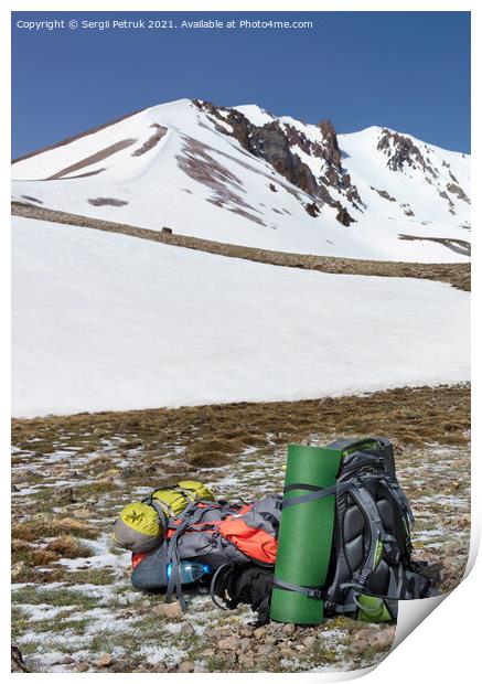 Camping equipment against the background of a snow-capped mountain and blue sky. Print by Sergii Petruk