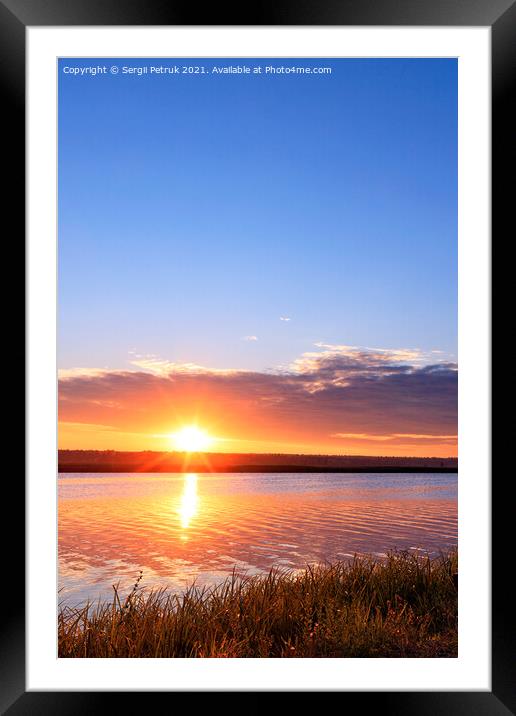 Morning dawn over the river, the bright rising sun rises above the horizon, the sun's rays are reflected in the undulating water surface. Framed Mounted Print by Sergii Petruk