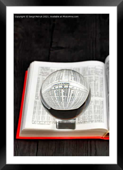 Crystal ball and opened book of ephemeris on blurred black wooden background. Framed Mounted Print by Sergii Petruk