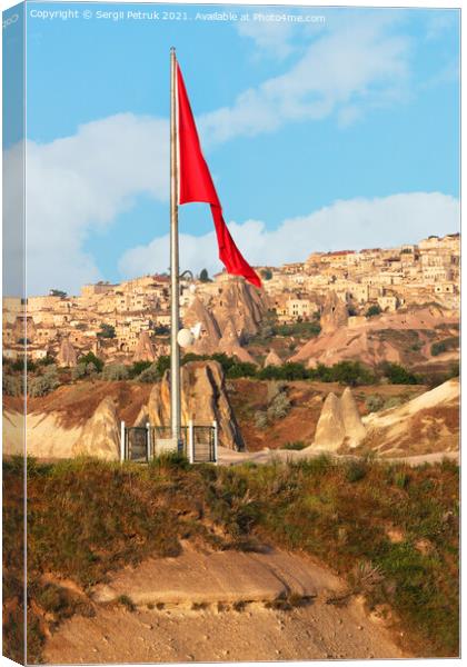 Turkey's large national flag towers over the ancient village of Uchisar in Cappadocia. Canvas Print by Sergii Petruk