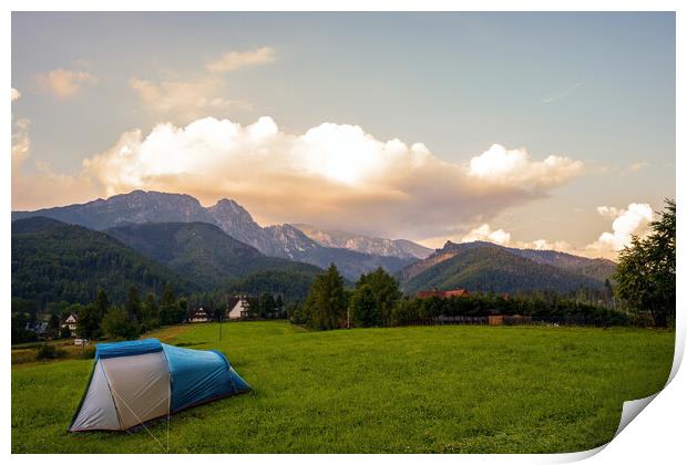 Camping tent put up on green grass meadow field against tatra mountains landscape during sunset sunrise and dramatic clouds, adventure in wild nature concept. Print by Arpan Bhatia