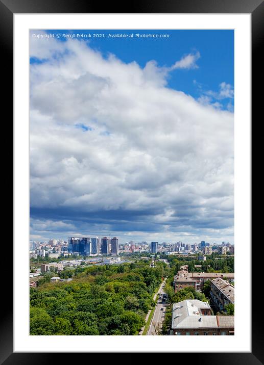 A large white and gray cloud loomed over a green park in the old residential area of the city and new buildings on the horizon against the backdrop of a bright summer day. Framed Mounted Print by Sergii Petruk