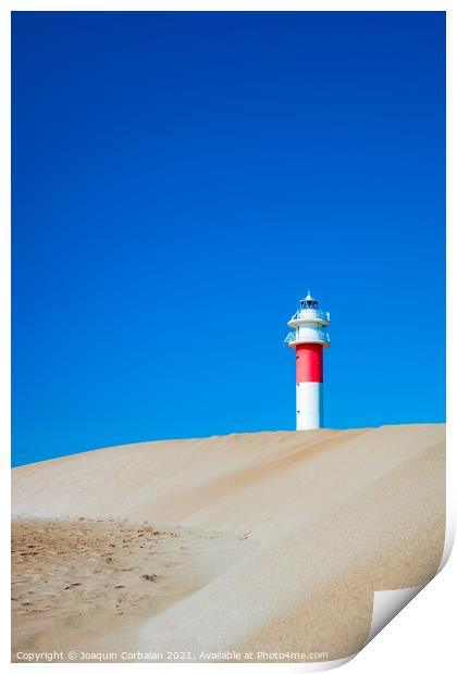 A lighthouse seen from the sand dunes of a beach on a sunny day. Print by Joaquin Corbalan
