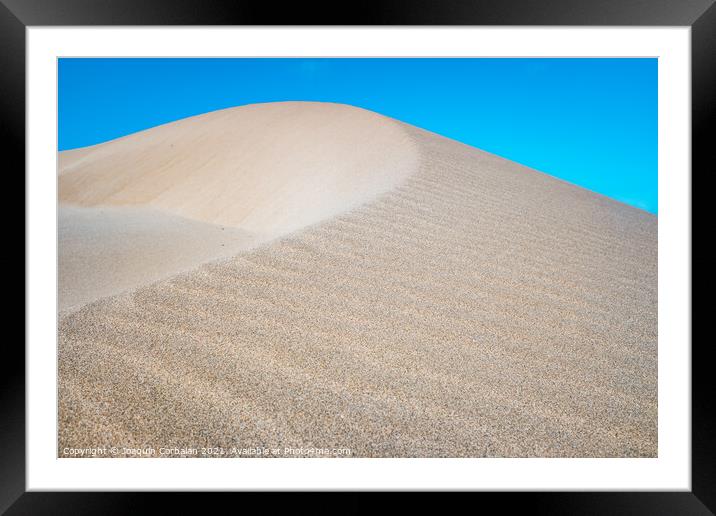 Fine sand blown by the wind creates dunes on the shores of the sea. Framed Mounted Print by Joaquin Corbalan