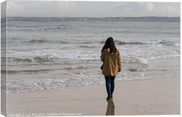 Woman walking on a beach with a yellow jacket in Peniche, Portugal Canvas Print by Luis Pina