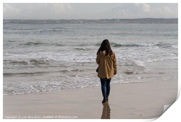 Woman walking on a beach with a yellow jacket in Peniche, Portugal Print by Luis Pina