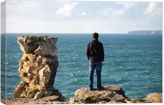 Caucasian man in sea cliffs landscape in Cabo Carvoeiro Cape looking at Berlengas Island, in Peniche, Portugal Canvas Print by Luis Pina