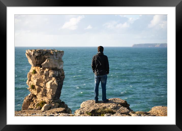 Caucasian man in sea cliffs landscape in Cabo Carvoeiro Cape looking at Berlengas Island, in Peniche, Portugal Framed Mounted Print by Luis Pina