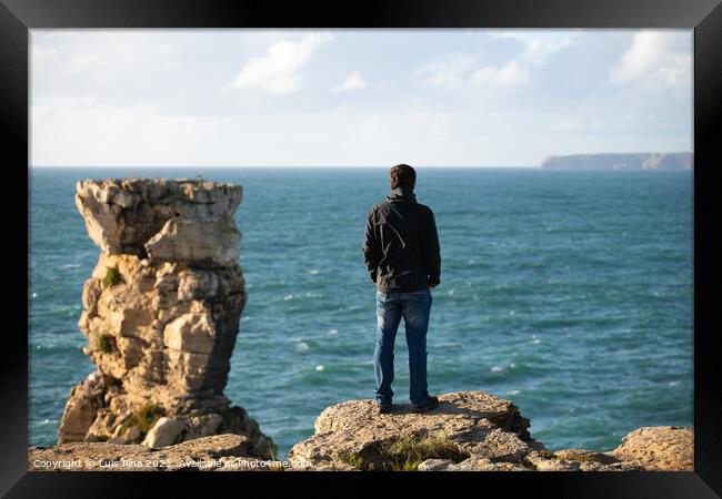 Caucasian man in sea cliffs landscape in Cabo Carvoeiro Cape looking at Berlengas Island, in Peniche, Portugal Framed Print by Luis Pina