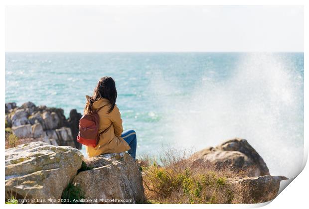 Caucasian traveler woman looking at the waves on the sea with a yellow jacket in Peniche, Portugal Print by Luis Pina