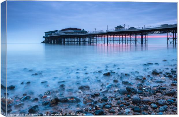Pebbles and Pier Canvas Print by Rick Bowden