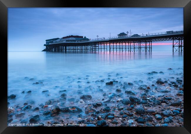 Pebbles and Pier Framed Print by Rick Bowden