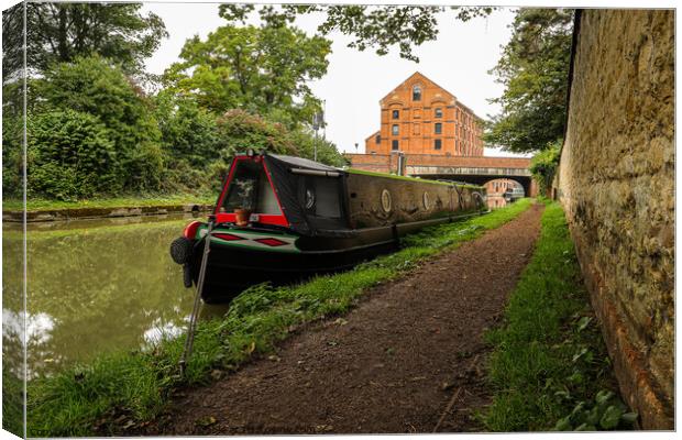 Lone narrowboat moored near the bridge Canvas Print by Clive Wells