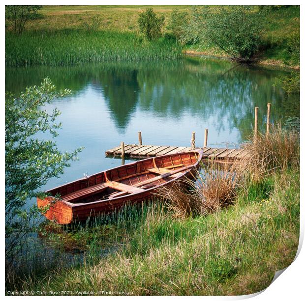 Traditional rowing boat moored Print by Chris Rose