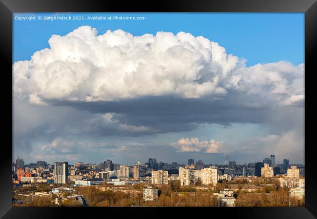 A large white-gray cloud hung over the city and was illuminated by the spring sunbeams. Framed Print by Sergii Petruk